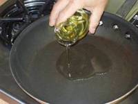 coconut oil pouring into frying pan